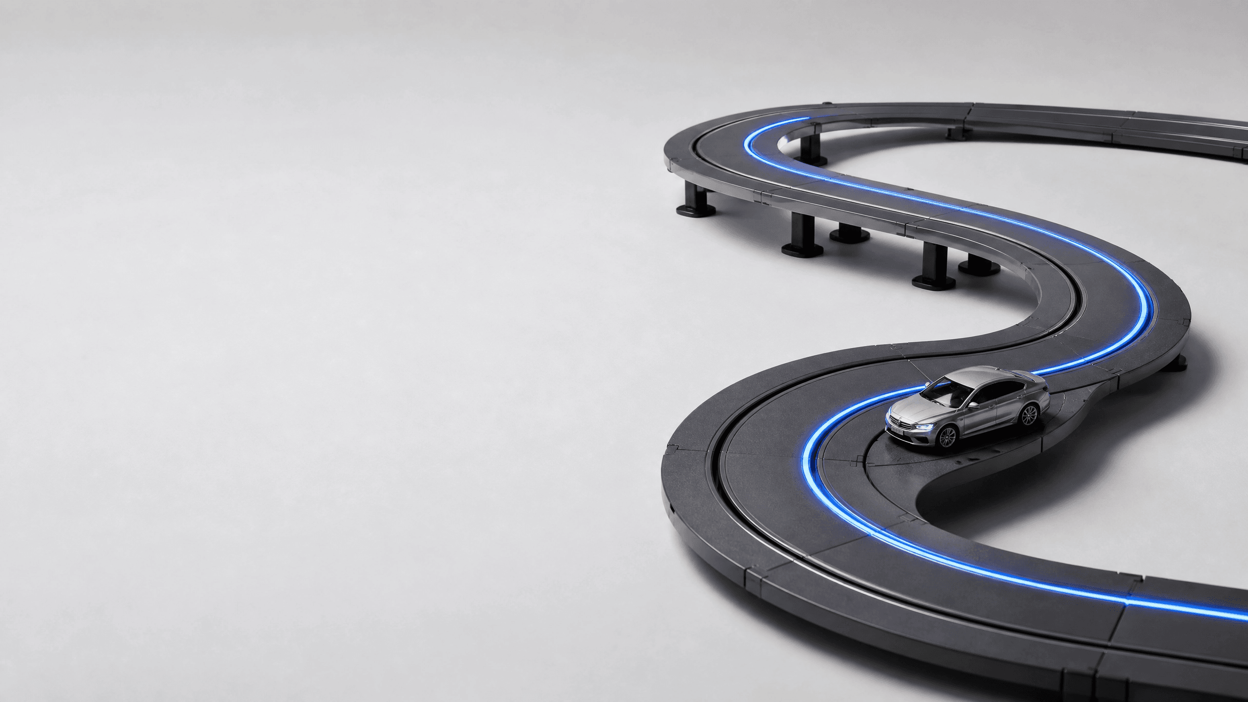 Pista modular Vitrack montada em curva S com trecho elevado, carrinho em corrida